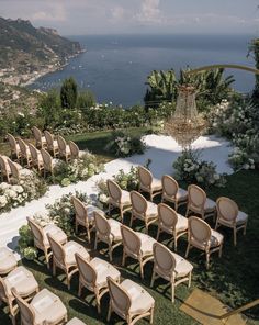 rows of chairs set up in front of an outdoor ceremony venue overlooking the ocean and mountains