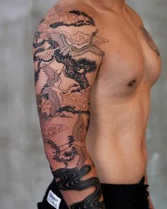 a man with a dragon tattoo on his arm and half sleeve is posing for the camera