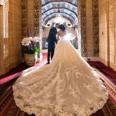 a bride and groom standing in an ornate archway at the end of their wedding day