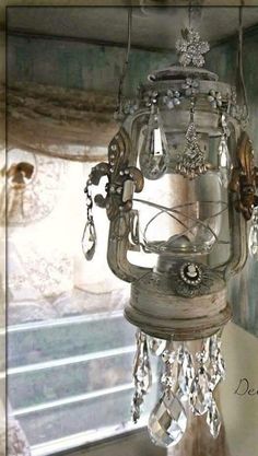 a bird feeder hanging from the side of a window sill with crystal beads on it