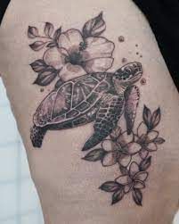 a black and white photo of a turtle with flowers on it's back leg