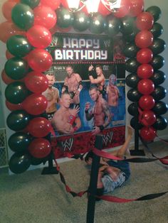 a man laying on the floor in front of a birthday photo frame with balloons around it