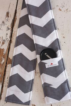 a pair of gray and white chevroned napkins with a black button in the pocket