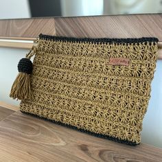 a brown and black purse sitting on top of a wooden table next to a mirror