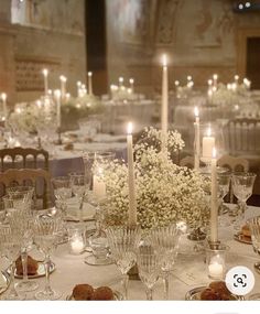 an image of a table setting with candles and flower centerpieces in the middle