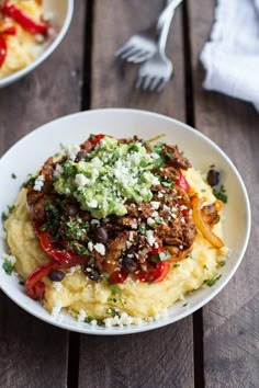 a white plate topped with mashed potatoes covered in meat and vegtables