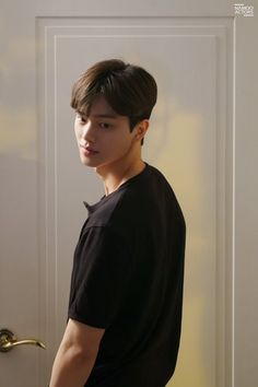 a young man standing in front of a door