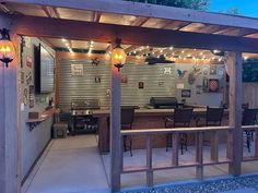 an outdoor kitchen with lights on the ceiling and grilling area in the back ground