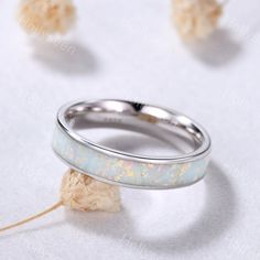 an opalite ring sits on a white surface with other opalites scattered around it