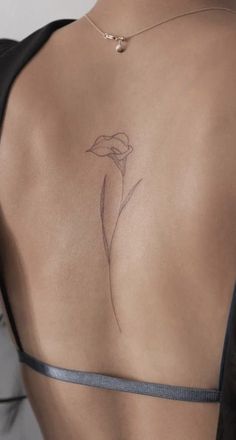 a woman's back with a flower tattoo on it