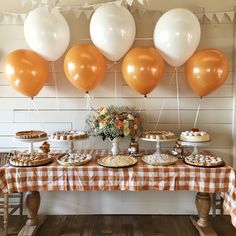 a table topped with lots of desserts and balloons