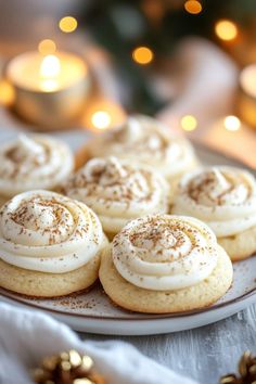 cinnamon rolls are on a plate next to candles