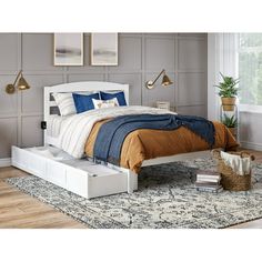 a bedroom with a bed, nightstands and rug on the floor in front of it