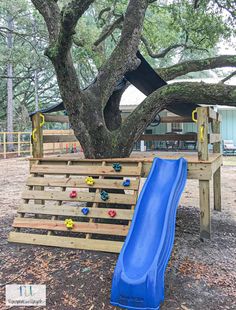 a blue slide sitting next to a tree