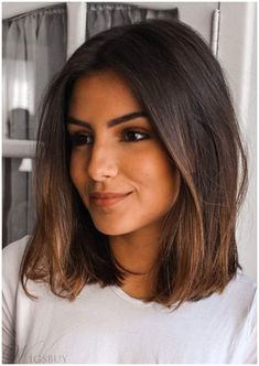 a close up of a person wearing a white t - shirt and smiling at the camera