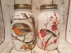 two glass jars with birds painted on them