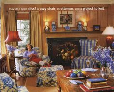 a woman sitting in a living room next to a fire place with blue and white furniture