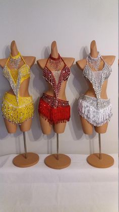 three female mannequins in different colors and sizes with beading on them