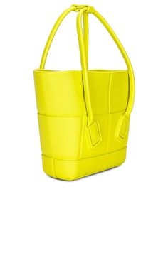 a bright yellow leather bag with handles and straps on the handle, sitting against a white background