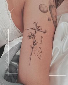 a woman's arm with a flower tattoo on it and the words love written in cursive writing