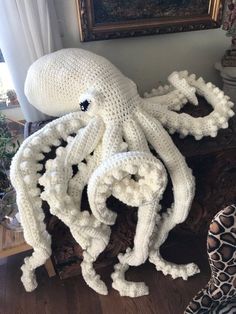 an octopus made out of yarn sitting on top of a wooden table