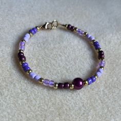 - One Of A Kind Beaded Bracelet - Featuring Light Purple, Dark Purple, And Gold Seed Beads With A White Pearl Bead At The Center - Gold Colored Hardware - Clasps Closed. No Stretch. - Size/ Circumference Is 7” - Handmade (By Myself). Perfect To Treat Yourself Or To Give As A Unique Gift! **Add 2 Jewelry Items Marked “2 For $20” To Your Bundle And I Will Send You An Offer For $20** Tags: Beaded, Handmade Jewelry, Colorblock, Ocean, Pearls Check Out The “Boutique” Tab In My Closet For Handmade Ear Single Strand Purple Beads For Gift, Purple Single Strand Beads For Gift, Purple Single Strand Beads As A Gift, Adjustable Purple Bracelets With Tiny Beads, Adjustable Purple Bracelet With Tiny Beads, Adjustable Purple Beaded Bracelets With Spacer Beads, Purple Tiny Beads Beaded Bracelets As Gift, Elegant Purple Beaded Bracelet With Colorful Beads, Adjustable Purple Bracelets With Spacer Beads