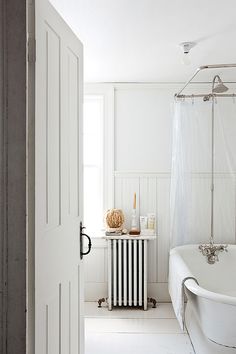 a bath room with a tub a sink and a mirror on the wall next to a door