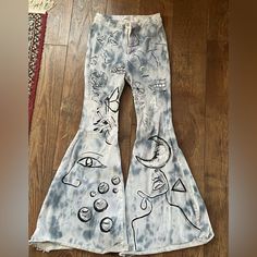 a pair of jeans with drawings on them sitting on the floor