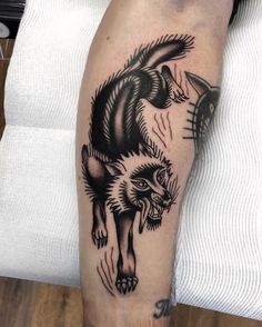 a black and white tattoo on the leg of a man with an animal in it