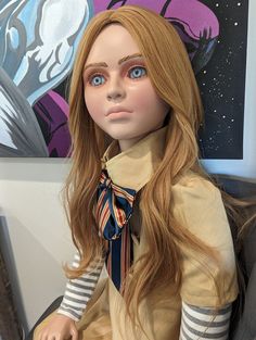 a doll with long hair sitting on a chair