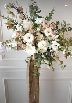 a bouquet of white flowers and greenery in a vase