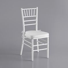 a white chair with a cushion on the seat and back rest, in front of a gray background