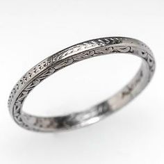 a silver ring with intricate designs on the inside and outside, set against a white background