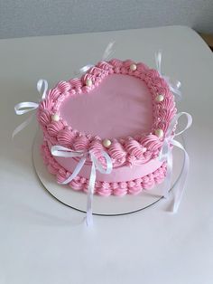 a pink heart shaped cake on a white plate