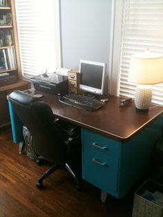 a desk with a computer on top of it in front of a bookshelf