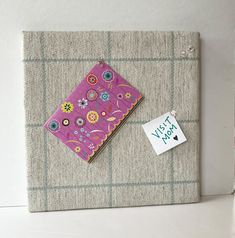 a piece of fabric with flowers on it sitting next to a small tag that says wish you