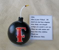 a black ornament with the letter f painted on it and a note attached to it