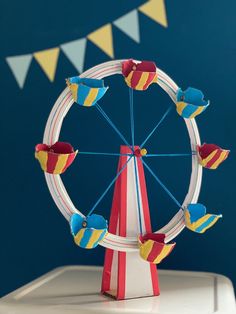 a toy ferris wheel sitting on top of a white table next to a blue wall