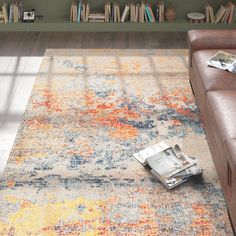 a living room with a couch, coffee table and bookshelf on the floor