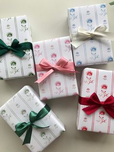 four wrapped gift boxes with bows on them