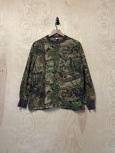 Large 50% Cotton 50% Polyester Pit to Pit 21" Back Collar to Bottom 26" Sleeve Length 22 1/2" Fall Camouflage T-shirt With Crew Neck, Green Military Crew Neck Top, Fall Camouflage Crew Neck T-shirt, Camouflage Graphic Print Relaxed Fit Tops, Khaki Military Crew Neck Top, Camouflage T-shirt For Fall, Camouflage Tops For Outdoor Fall Activities, Green Military Style Tops With Graphic Print, Camouflage Military Style Tops For Streetwear