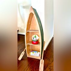 a wooden boat shaped shelf sitting on top of a hard wood floor next to a wall