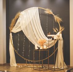 a decorated stage with white drapes and candles