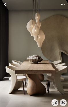 a dining room table with chairs and lights hanging from it's ceiling, in front of an elephant sculpture