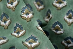 a close up view of a green tie with blue flowers on it