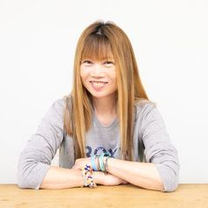 a woman sitting at a table with her arms crossed