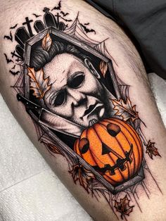 a man's leg with a skull and pumpkin on it