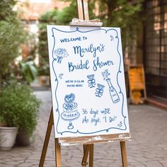 a welcome sign for a bridal shower is on an easel in front of a building