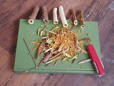 a green cutting board topped with lots of cut up vegetables next to a red knife