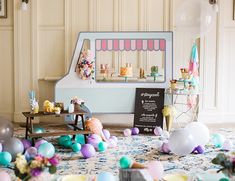 an assortment of desserts and candies on a table in front of a candy shop